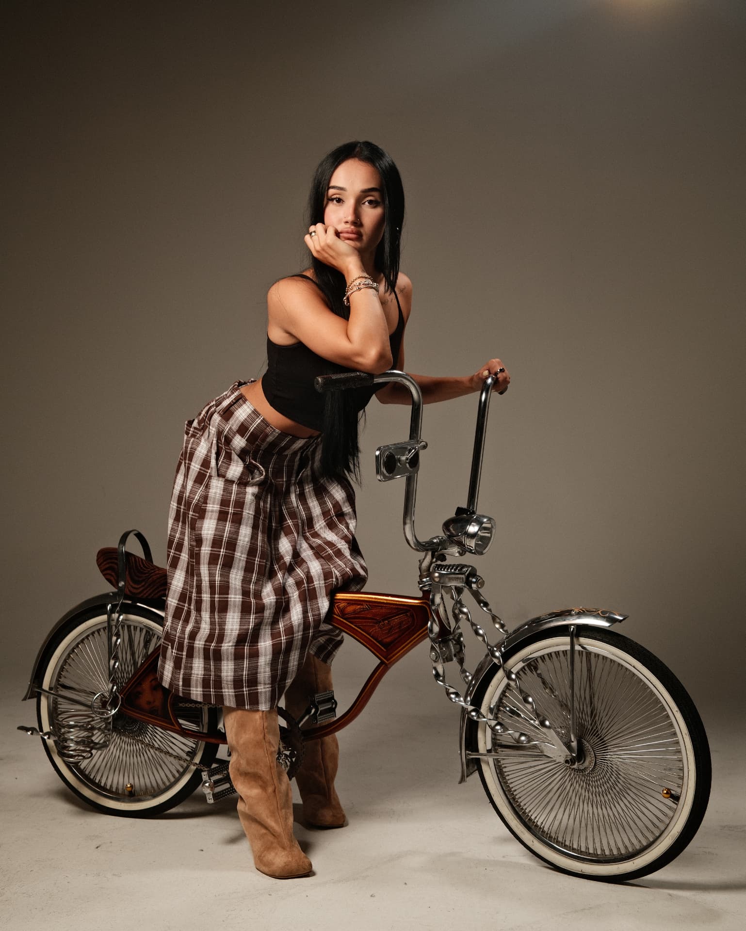 Portrait leaning on a customized lowrider bicycle in studio